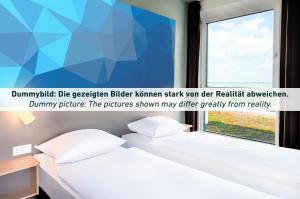 爱尔福特B&B Hotel Erfurt City-West的一间卧室设有一张床和一个窗口