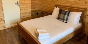 - une chambre avec un grand lit et des murs en bois dans l'établissement Superior Glamping Pod with Hot Tub, à Frodsham