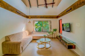 salon z kanapą i stołem w obiekcie SaffronStays Eden, Nashik - pet-friendly villa with pool, jacuzzi & grape farm w mieście Nashik