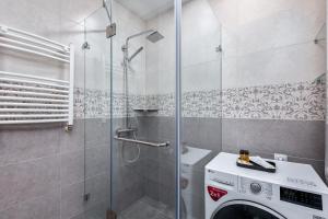 bagno con doccia e lavatrice. di HCG Panorama Villa Deluxe Apartment a Bakuriani