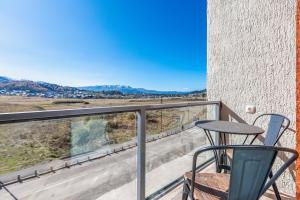 balcone con tavolo e sedie. di HCG Panorama Villa Deluxe Apartment a Bakuriani