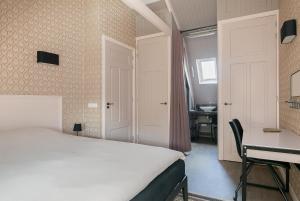 Schlafzimmer mit einem Bett, einem Schreibtisch und einem Tisch in der Unterkunft Molepôlle 7 - Stadslogementen Franeker in Franeker