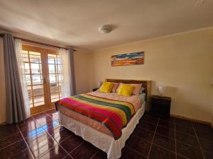 - une chambre avec un lit doté d'oreillers jaunes et d'une fenêtre dans l'établissement Anka Lodge Quitor, à San Pedro de Atacama