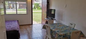 een kamer met een tafel en een televisie en een bed bij La Isla - Araminda in Balneario Argentino