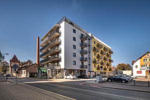 un gran edificio blanco en una calle de la ciudad en Apartments Centrum Hviezdoslav, en Poprad