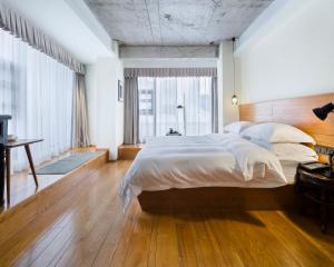 1 dormitorio con cama grande y ventana grande en Zhuhai Bei Shan Ju Art Hotel, en Zhuhai