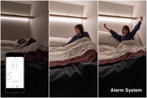 a woman laying in bed with her arms in the air at The Millennials Kyoto in Kyoto