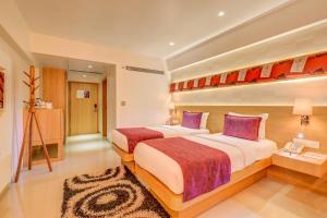 una camera d'albergo con due letti di The SSK Solitaire Hotel & Banquets a Nashik