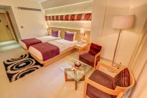 una camera d'albergo con due letti e una sedia di The SSK Solitaire Hotel & Banquets a Nashik