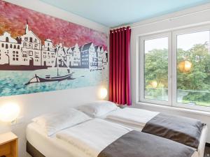 Un pat sau paturi într-o cameră la B&B Hotel Lüneburg