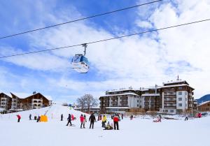 eine Gruppe von Menschen auf einem Skilift im Schnee in der Unterkunft MPM Hotel Sport Ski-in, Ski-out in Bansko