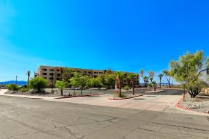 uma rua vazia em frente a um edifício com palmeiras em Studio 6 Suites Lake Havasu City AZ em Lake Havasu City