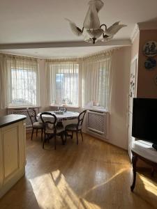 a dining room with a table and chairs and a ceiling fan at Rest house in Truskavets