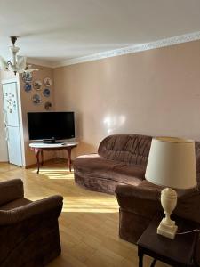 a living room with a couch and a flat screen tv at Rest house in Truskavets