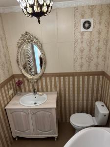 a bathroom with a sink and a mirror and a toilet at Rest house in Truskavets