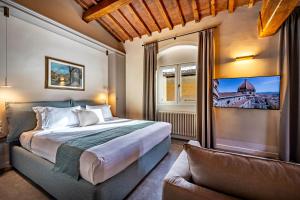 um quarto com uma cama grande e um sofá em Dimora Collection - Le Torri - Boutique Luxury Suites - Adults Only em Florença