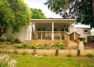 ein Haus mit einer Veranda und einer Terrasse in der Unterkunft Birdsong Cottage in Paraparaumu