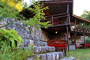 eine Blockhütte mit einer Treppe, die zu einem Gebäude führt in der Unterkunft Melnik Pyramids Guesthouse in Zlatkov Chiflik