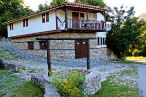 ein Steinhaus mit Balkon darüber in der Unterkunft Melnik Pyramids Guesthouse in Zlatkov Chiflik