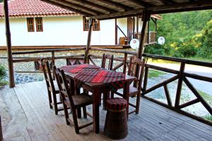 einen Tisch und Stühle auf der Terrasse eines Hauses in der Unterkunft Melnik Pyramids Guesthouse in Zlatkov Chiflik