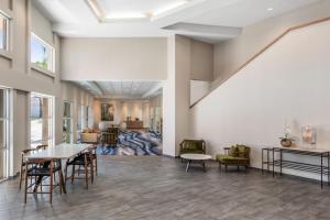 eine Lobby mit Tischen und Stühlen und ein Wohnzimmer in der Unterkunft Fairfield Inn and Suites by Marriott San Jose Airport in San Jose