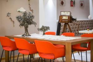 una mesa con sillas naranjas y una cámara en Sweet Home Hotel, en Atenas