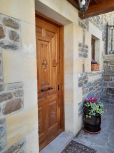 - une porte en bois sur un bâtiment en pierre orné de fleurs dans l'établissement Casa del Horno, à Potes