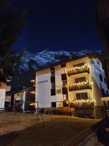 ein Hotel in der Nacht mit einem Berg im Hintergrund in der Unterkunft Haus Kandahar in Saas-Fee