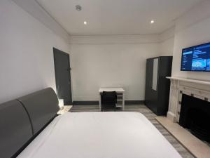 Camera con letto, TV e camino. di Rooms in Modernised Victorian House a Croydon