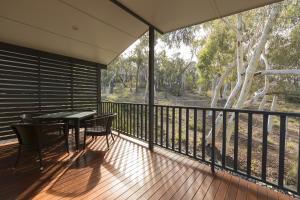 eine Veranda mit einem Tisch und Stühlen auf einer Terrasse in der Unterkunft Alivio Tourist Park Canberra in Canberra