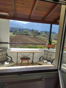 een tafel en stoelen op een balkon met uitzicht bij VILLA DOROTHY STUDIO in Delfoi