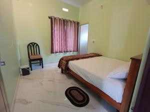 1 dormitorio con 1 cama, 1 silla y 1 ventana en Sili Homestay, en Madikeri