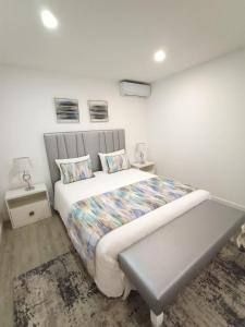 a bedroom with a bed and a bench in it at Casa Fonte Nova in Nazaré