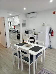 a white dining room table and chairs in a kitchen at Casa Fonte Nova in Nazaré