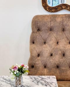 a vase of flowers on a table next to a couch at Hotel Don Rodrigues in Tavira