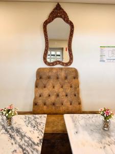 a mirror on a wall with a table and a chair at Hotel Don Rodrigues in Tavira