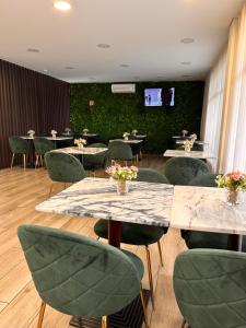 a dining room with tables and chairs and a tv at Hotel Don Rodrigues in Tavira