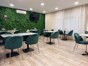 a conference room with tables and chairs and a green wall at Hotel Don Rodrigues in Tavira