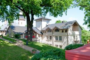 una grande casa bianca con un albero in cortile di Hotel Villa Monte Vino a Potsdam