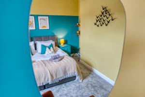 una camera con letto e specchio di XMAS SPECIAL OFFER!! 2-BR Modern, Stylish & Stunning Contractor House, Prime Portsmouth Location with Parking - By Blue Puffin Stays a Portsmouth