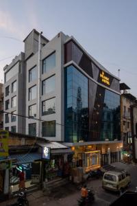 a building with a sign on it on a street at Hotel Vilvah in Coimbatore