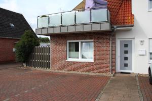 una casa in mattoni con balcone sopra di Ferienwohnung "TimeOut" a Hage