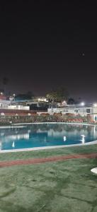 ein großer Pool mit Tischen und Stühlen in der Nacht in der Unterkunft Relax in pasito blanco camping house in Maspalomas