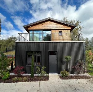 une maison avec un balcon au-dessus dans l'établissement Cabanes avec jacuzzi les pieds dans la vignes, 