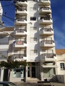 un edificio alto y blanco con balcones. en Appartement, praia da rocha, PORTIMAO, en Portimão