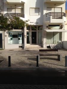 un banco sentado frente a un edificio en Appartement, praia da rocha, PORTIMAO, en Portimão