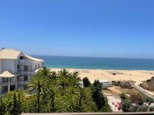 vistas a una playa con un edificio y al océano en Appartement, praia da rocha, PORTIMAO, en Portimão