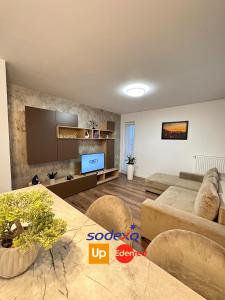 een woonkamer met een bank en een tv bij Deluxe Cozy Apartments - Coresi Mall #Brasov in Braşov