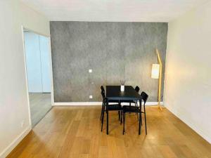 une salle à manger avec une table et des chaises noires dans l'établissement Appartement lumineux et spacieux proche gare, à Villeurbanne