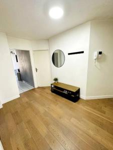 - un salon doté de parquet et d'un miroir dans l'établissement Appartement lumineux et spacieux proche gare, à Villeurbanne